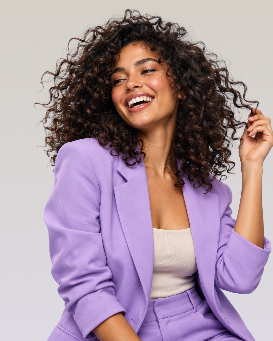 Woman wearing full curls and a lavender suit